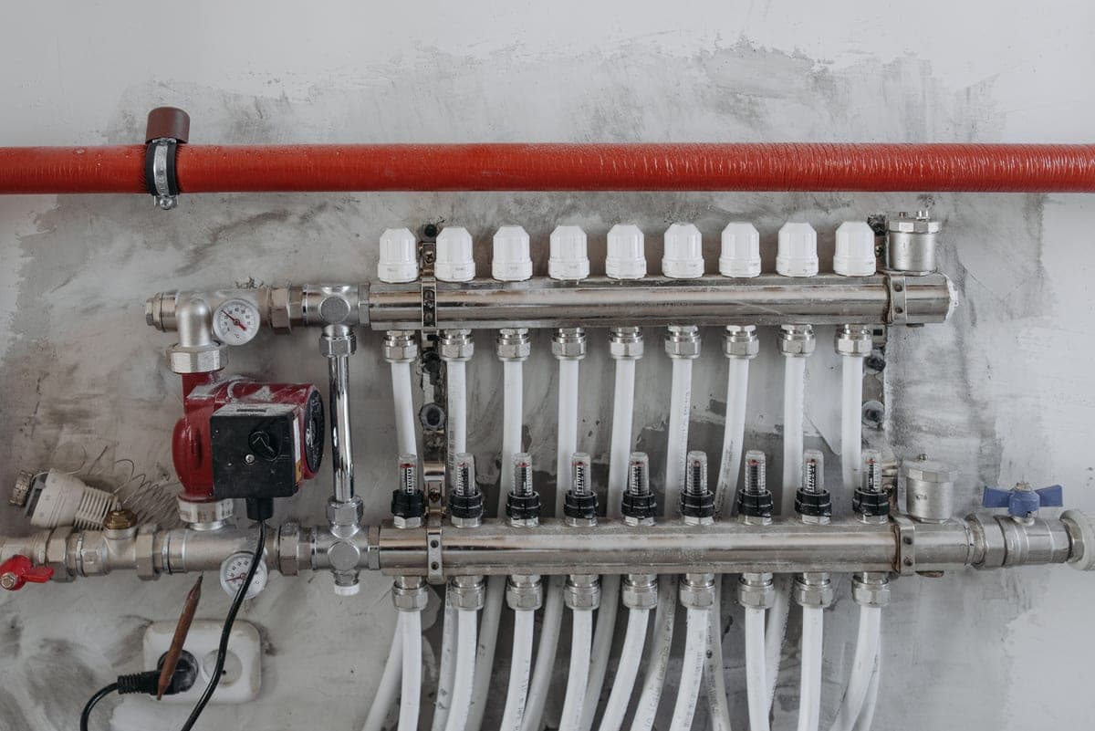 A plumbing manifold with multiple pipe runs leaving it