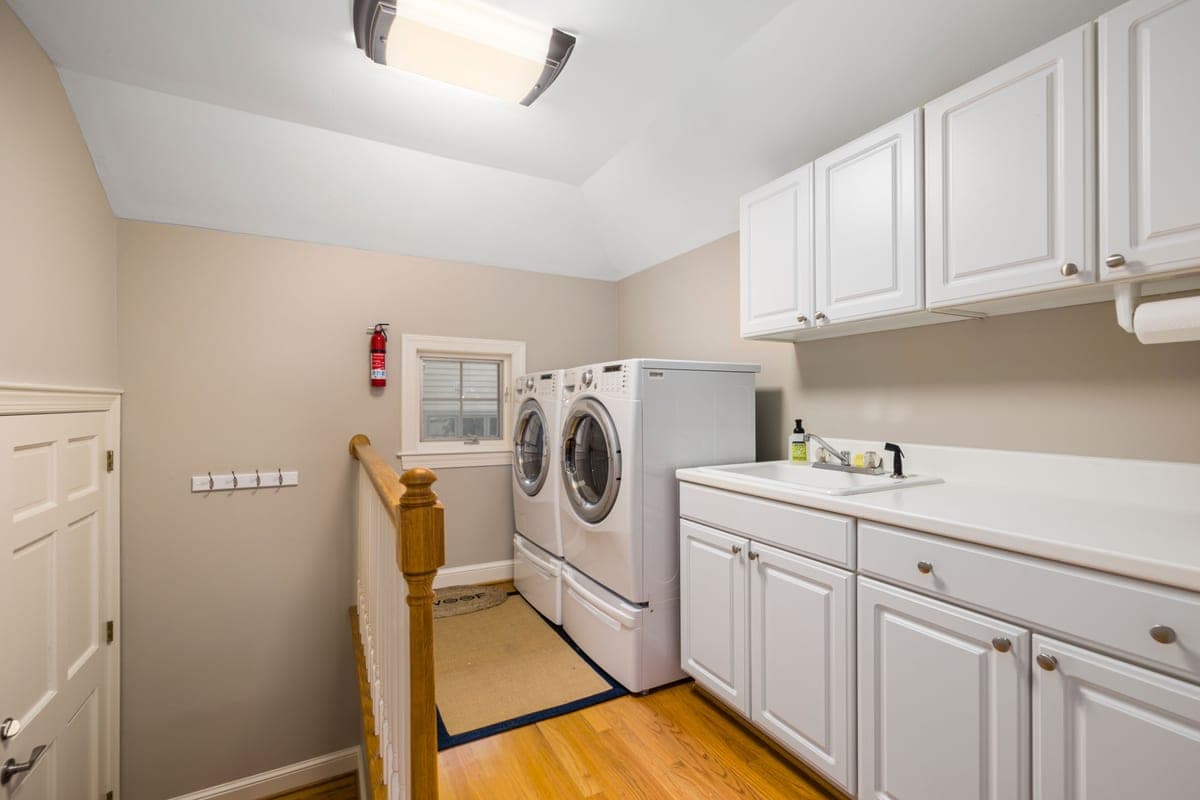 A tidy, daylit laundry and utility room with cabinets and a folding counter